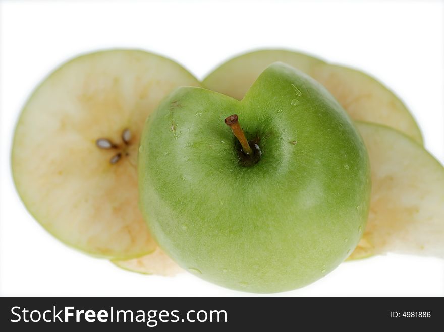 Cut fresh green apple slices are placed on each other over white