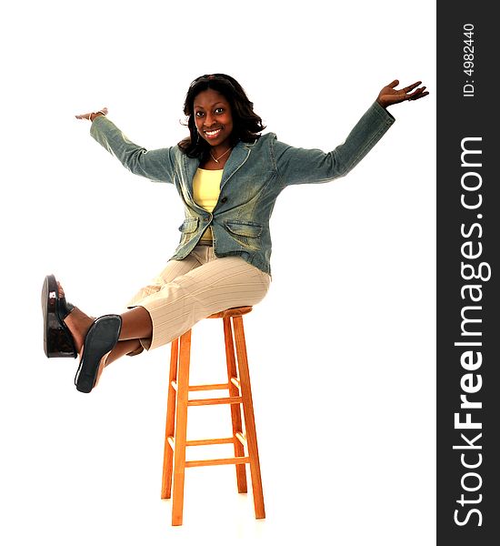 Ecstatic African American woman on a high stool. Isolated on white. Ecstatic African American woman on a high stool. Isolated on white.