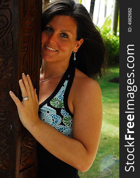 Black and white of a woman posing against carved wooden pole in the Dominican Republic. Black and white of a woman posing against carved wooden pole in the Dominican Republic