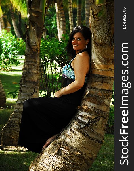 Beautiful woman posing against palm tree in a palm garden in the Dominican Republic. Beautiful woman posing against palm tree in a palm garden in the Dominican Republic