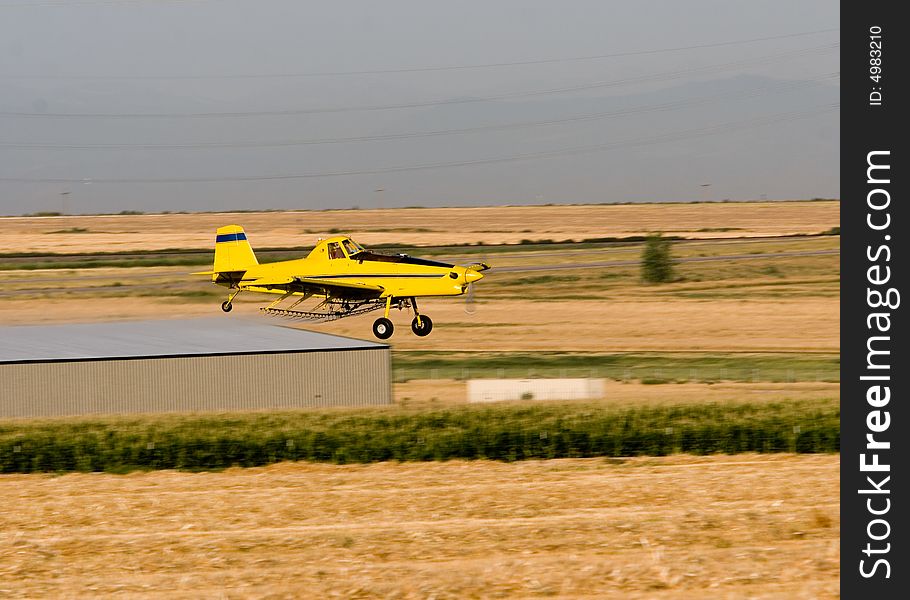 A crop dusting airplane working a corn fiel in Colorado. A crop dusting airplane working a corn fiel in Colorado
