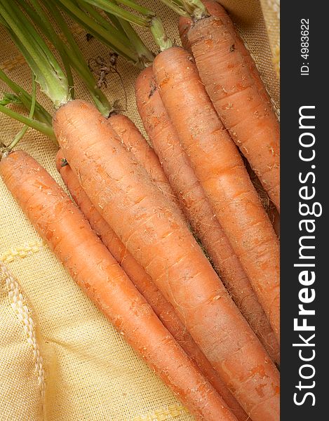 Bunch of fresh carrots on yellow tablecloth