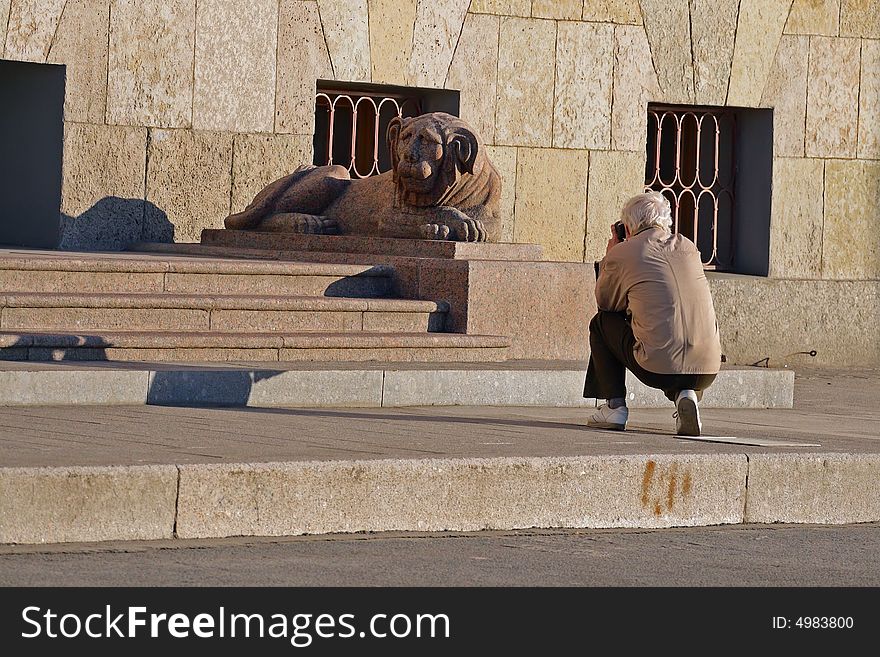 Hiker take a photograph granite sculpture lion