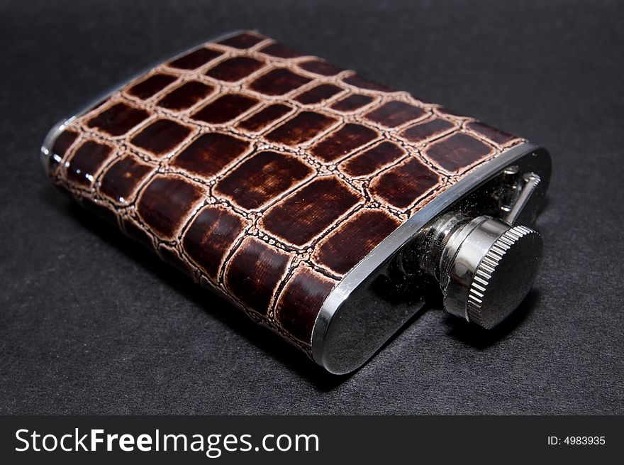 Metal flask bottle over black background