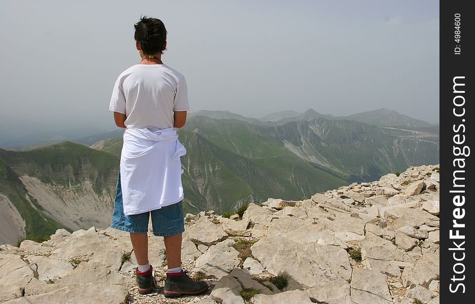 A boy stands atop Monte Vettore, highest peak in the central Apennines, Italy. A boy stands atop Monte Vettore, highest peak in the central Apennines, Italy