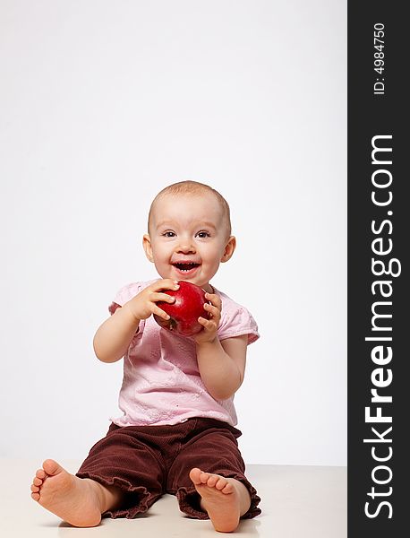 Portrait of happy baby with apple