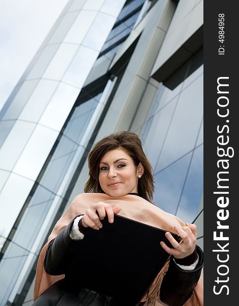 An image of a girl with notebook on background of building. An image of a girl with notebook on background of building