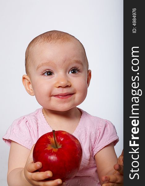 Portrait of happy baby with apple