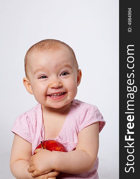 Portrait of happy baby with apple