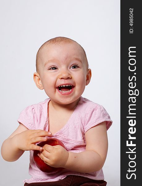 Portrait of happy baby with apple