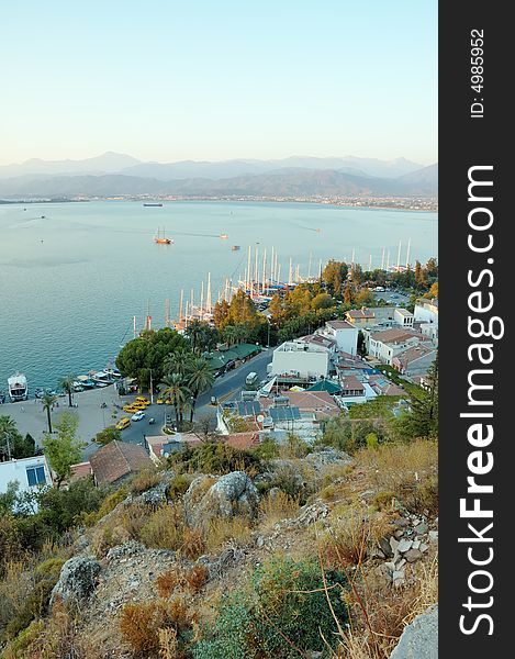 Top-down view on the seaside town and mountains behind sea bay. Top-down view on the seaside town and mountains behind sea bay