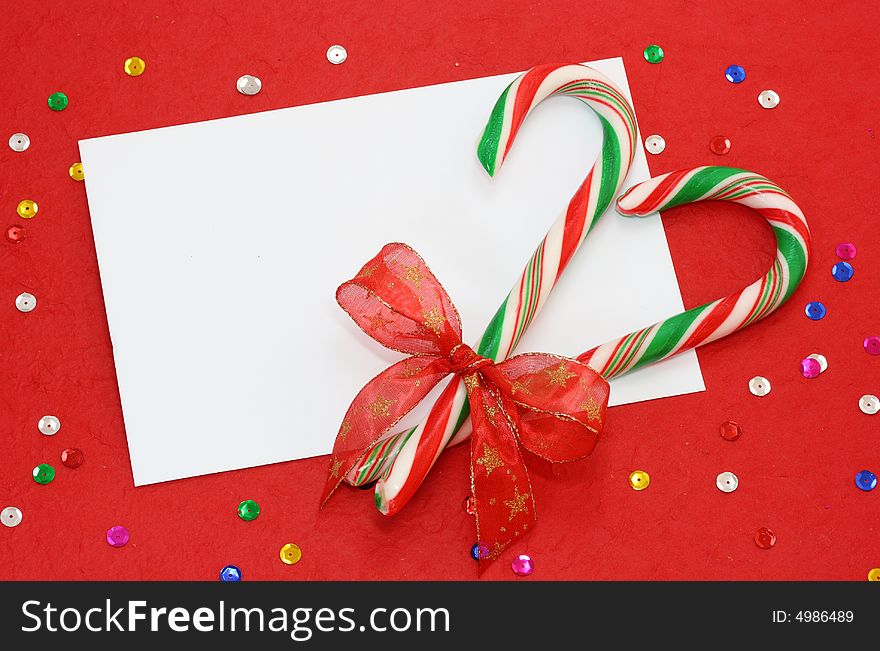 Red christmas background with blank note and candy canes on red