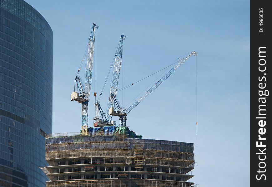 Three lifting cranes on the top of the building been constructed