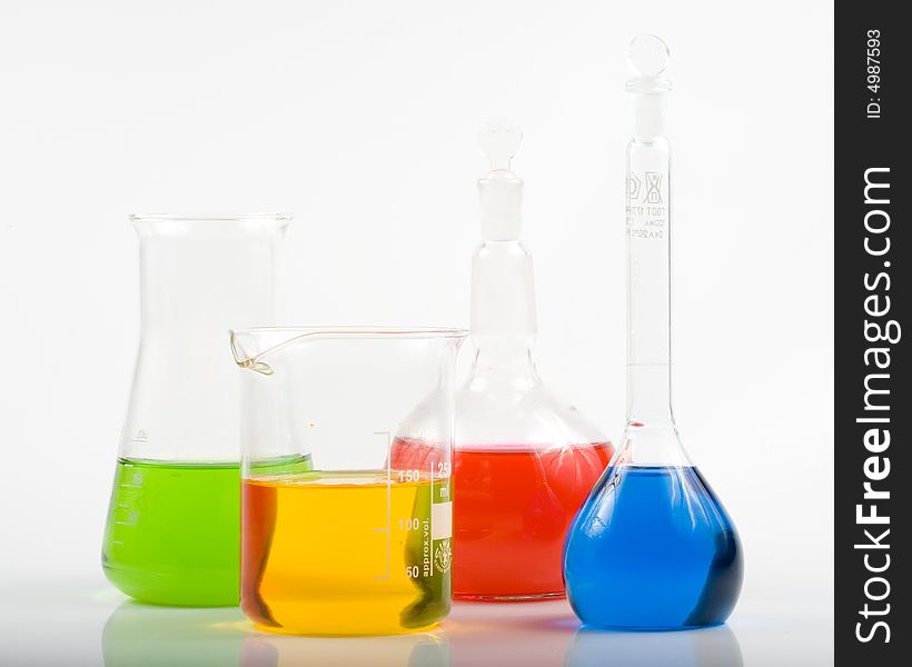 Various colorful flasks over white background