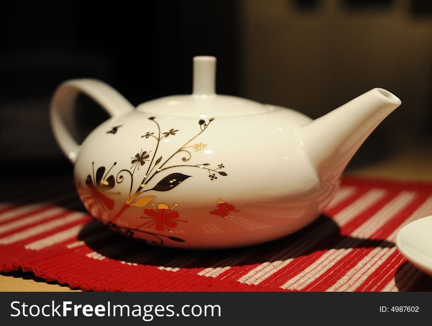 White teapot with beutiful flower pattern