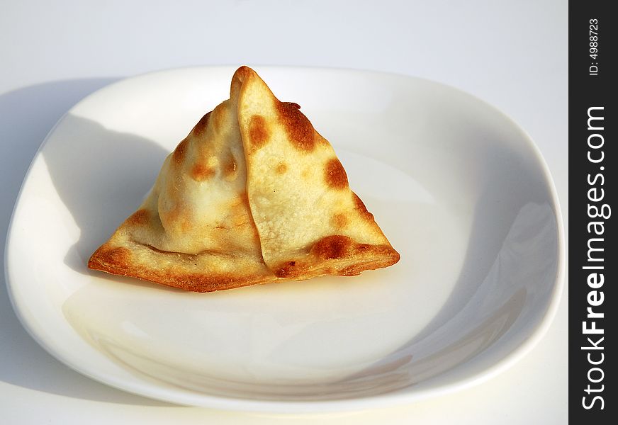 Freshly baked vegetarian Samosa on a white plate