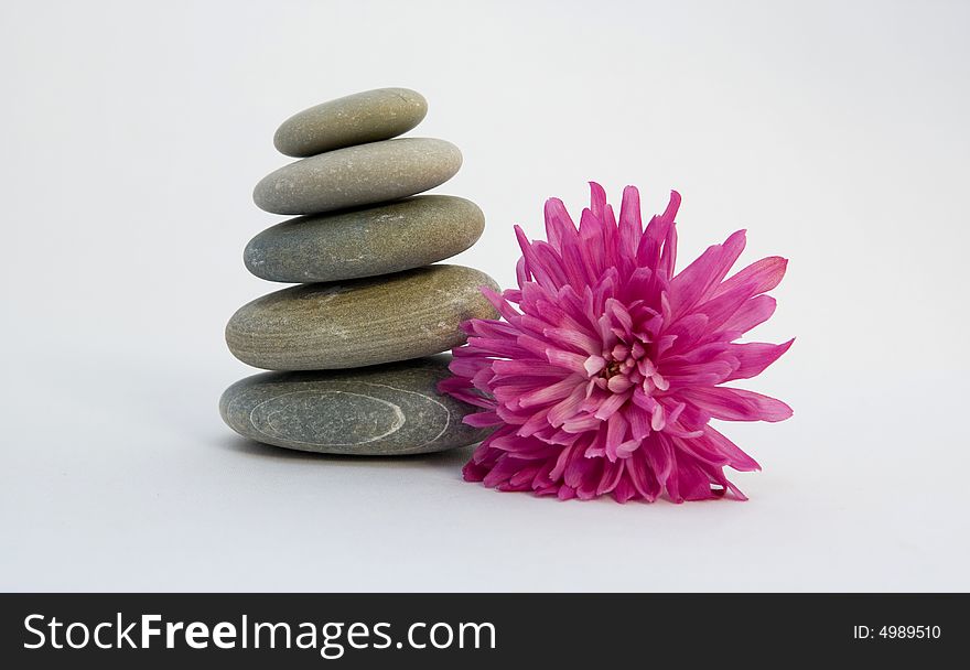 Pyramid from stones with a flower on a white background