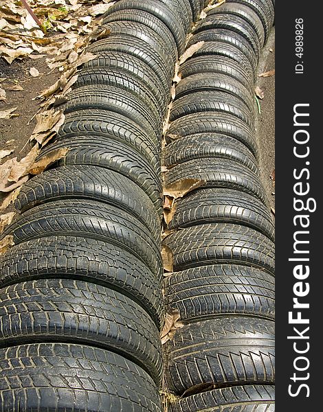 A wall worn rubber tyres illustrating environmental waste. A wall worn rubber tyres illustrating environmental waste.