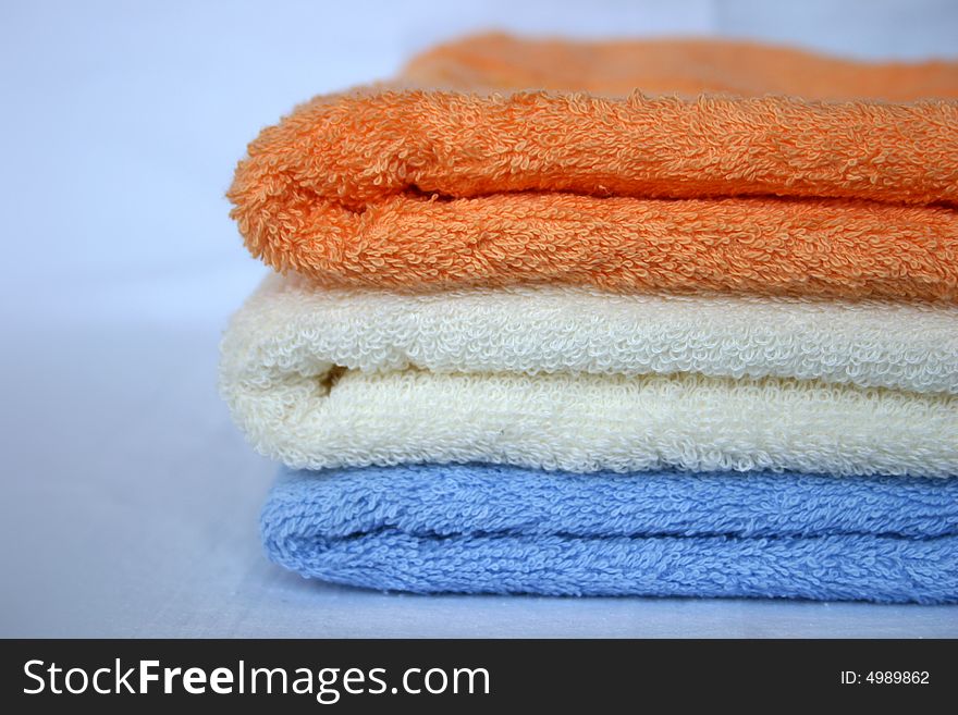 Three coloured towels: orange, white, blue