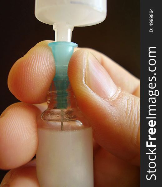 Hand with syringe and ampule - detail from laboratory.