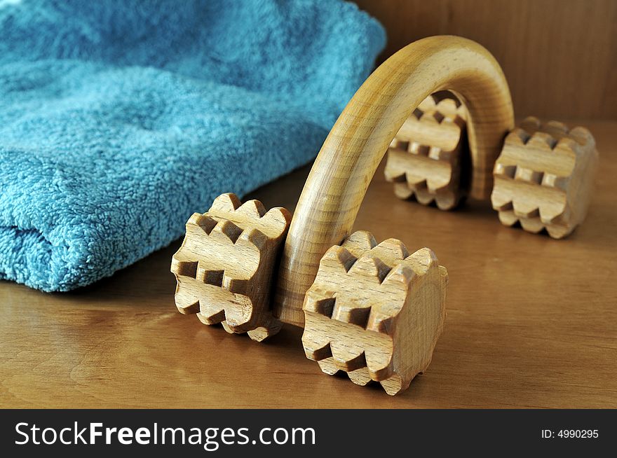 A wooden body massager and a blue towel