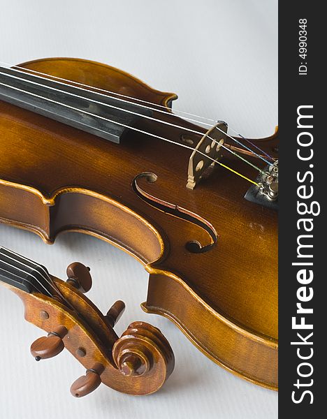 Violin on white background, tuning knobs from other violin