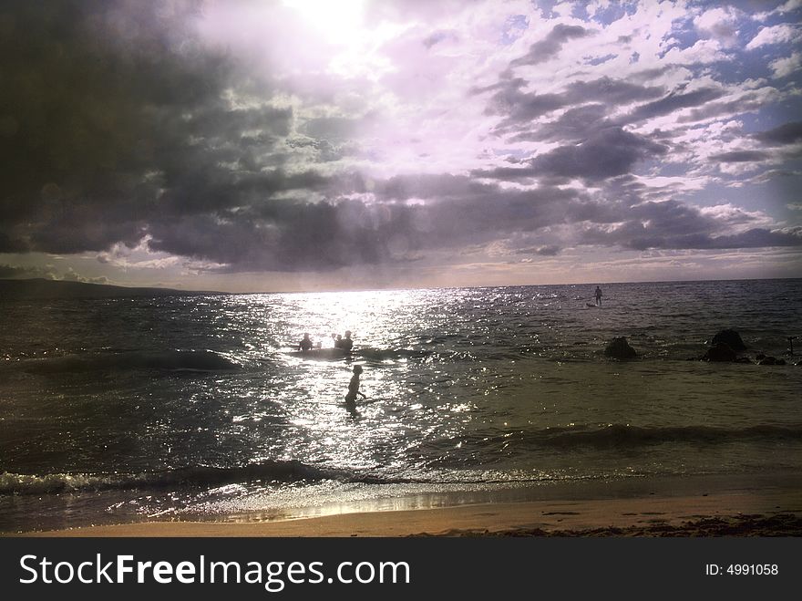 People in the ocean meeting sunset. People in the ocean meeting sunset