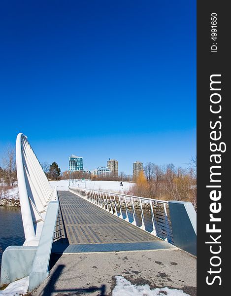 A metal bridge over a river and modern buildings in the background. A metal bridge over a river and modern buildings in the background