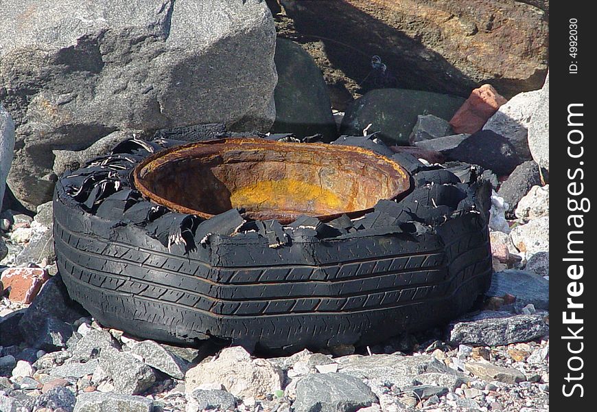 Old degrated tire among rocks. Old degrated tire among rocks