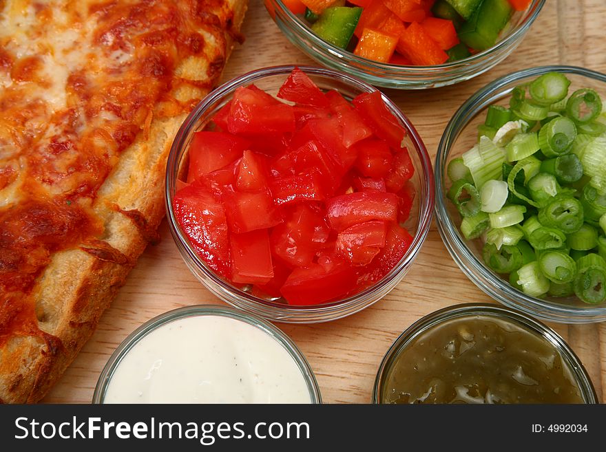 Bowl of diced tomatoes with veggies and cheesebread pizza.