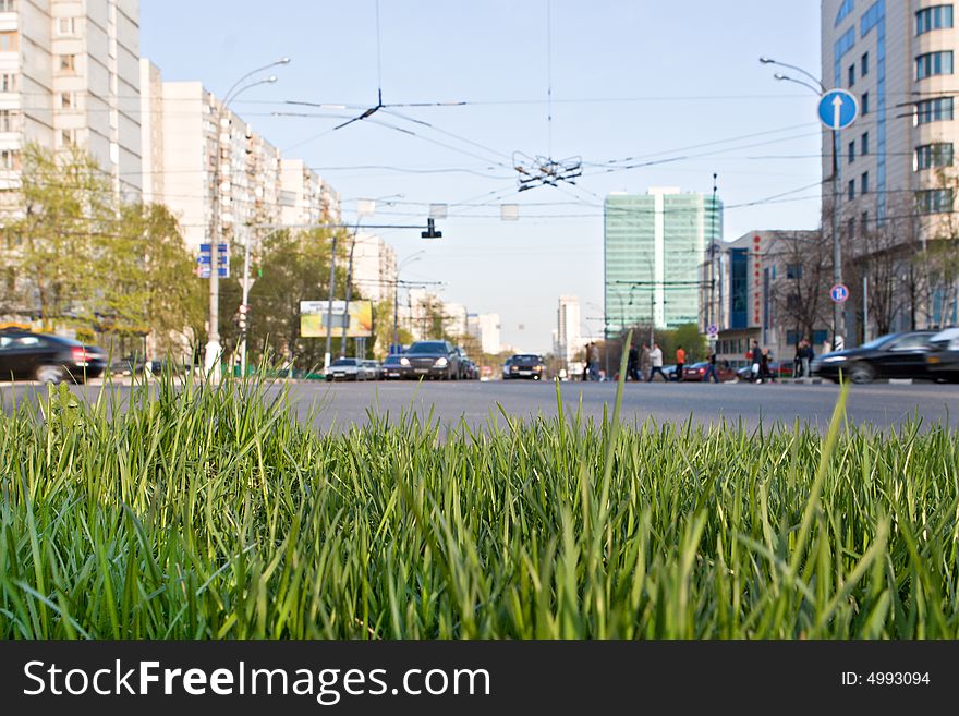 Lawn with a green grass on a background of an automobile highway. Lawn with a green grass on a background of an automobile highway