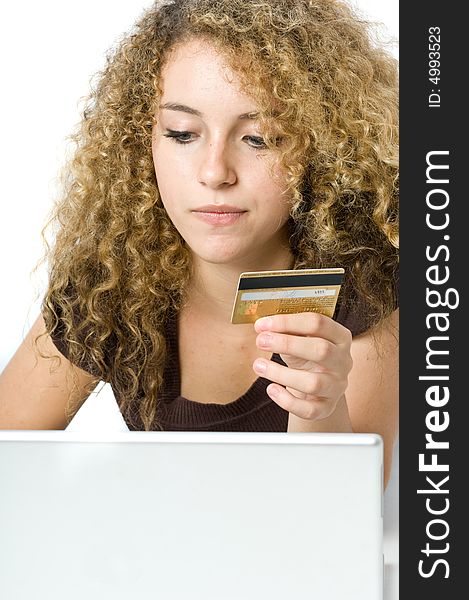 A beautiful young women using a credit card and a computer to shop online. A beautiful young women using a credit card and a computer to shop online