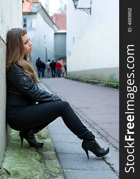 Portrait of the girl near wall in an old town