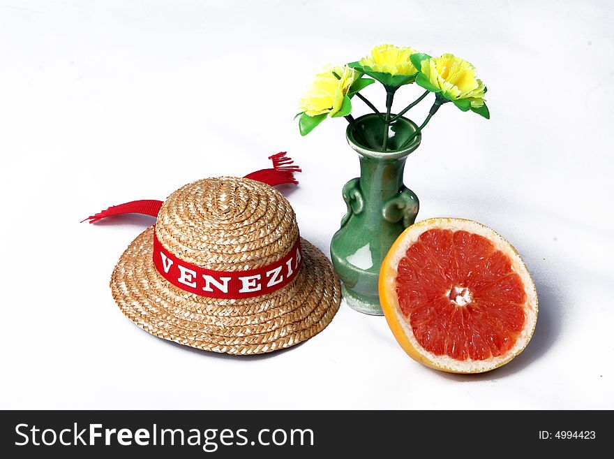 A grapefruit, a hat and flowers