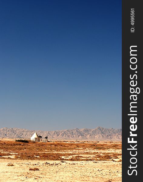 Small building in desert with mountains