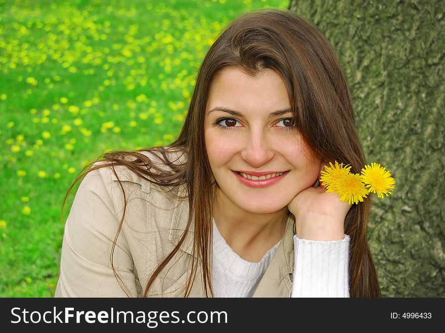 Smiling girl with yellow flowers and tree