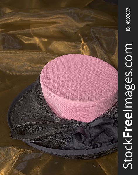 Pink and black ladies hat on gold background