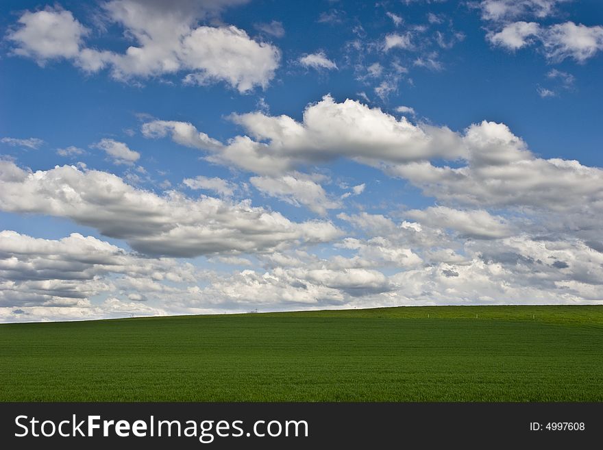 The storm is over: cloudy blue sky on green field. The storm is over: cloudy blue sky on green field