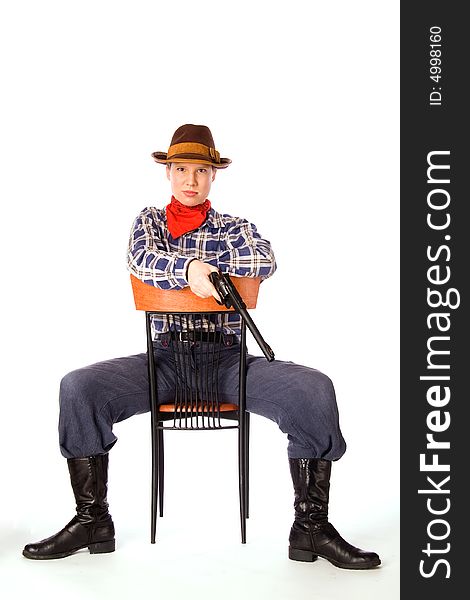 Resolute cowgirl with gun sitting on the chair (isolated on white)