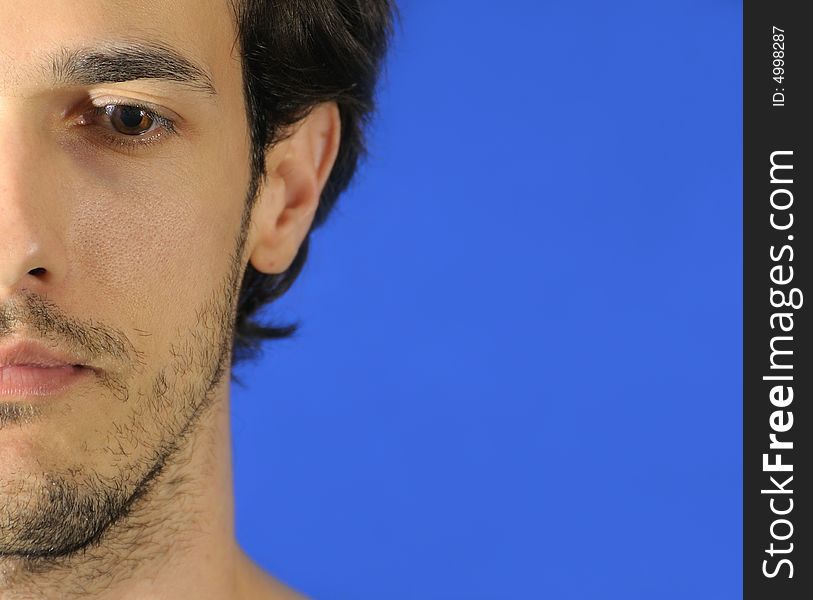 Portrait of pensive young man over blue background. Portrait of pensive young man over blue background