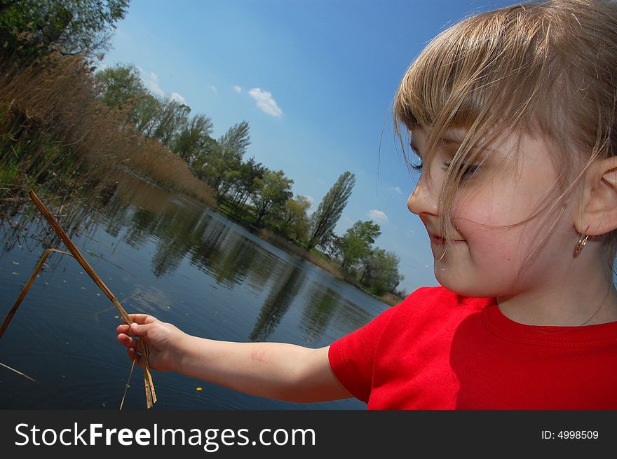 Little girl playing with a stick pretending she is fishing. Little girl playing with a stick pretending she is fishing