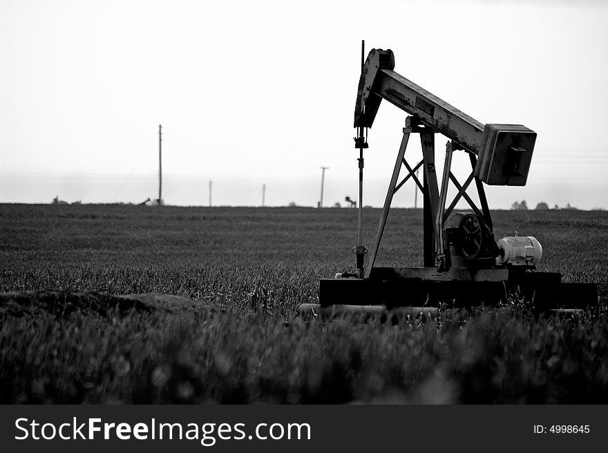 Black and white view of pump jack in countryside field. Black and white view of pump jack in countryside field.
