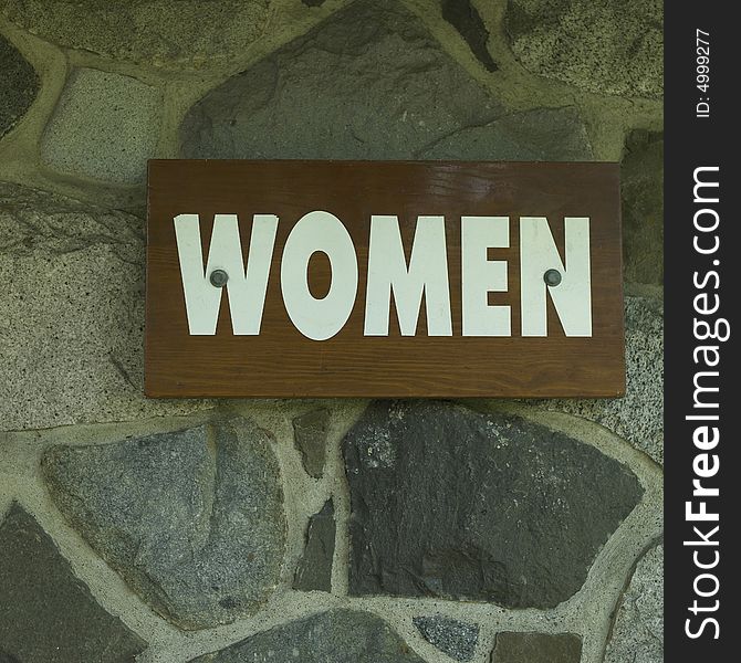 Women sign on a stone wall