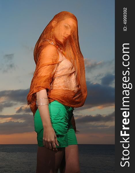 Portrait of seductive woman covered by orange veil. Portrait of seductive woman covered by orange veil