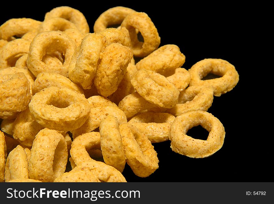 Pile of honey loops breakfast cereals isolated on black. Pile of honey loops breakfast cereals isolated on black.