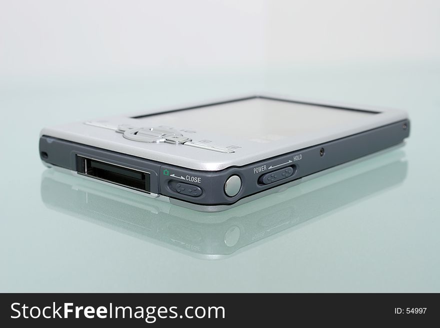 Silver palmtop (personal organizer) on a textured glass office desk. Silver palmtop (personal organizer) on a textured glass office desk.