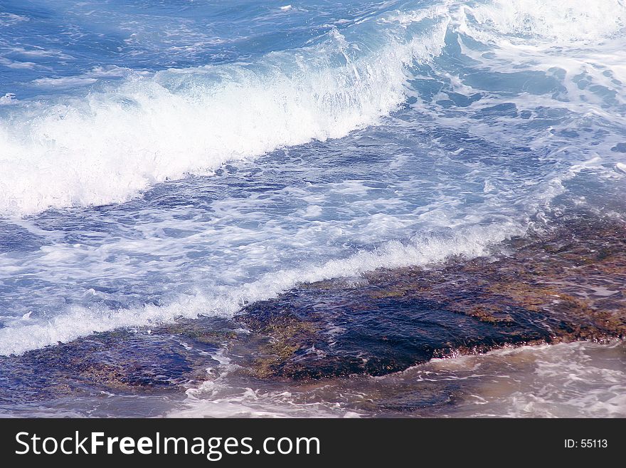 Blue water splashing over rocks. Blue water splashing over rocks