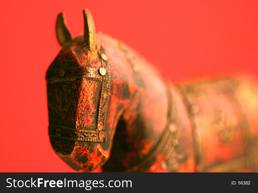 Macro shot of a lovely wooden horse over a red backgrown. Macro shot of a lovely wooden horse over a red backgrown