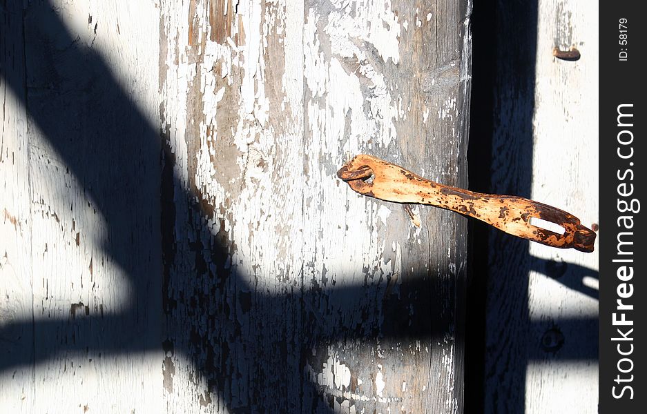 Shadow on a door with an old hasp. Shadow on a door with an old hasp