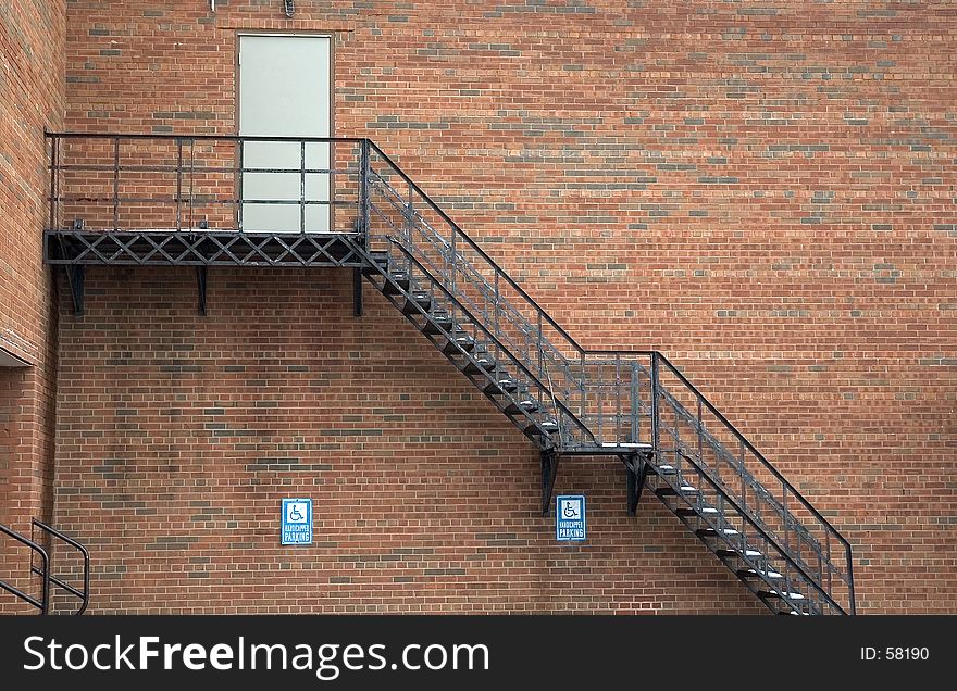 A metal Staircase leads to a second floor door in the side of a building. A metal Staircase leads to a second floor door in the side of a building.